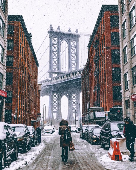 person walking in snow in Brooklyn New York towards Brooklyn Bridge