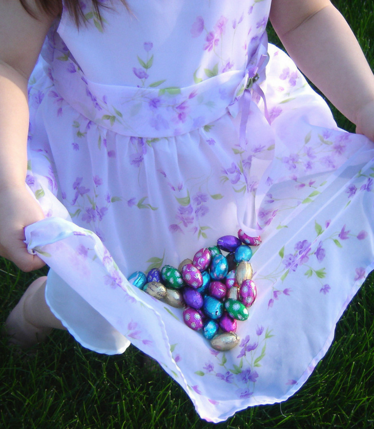little girl collecting Easter eggs at Easter egg hunt