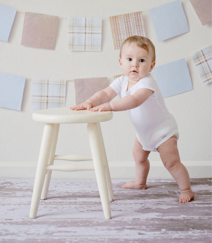 baby toddler standing at stool taking first steps