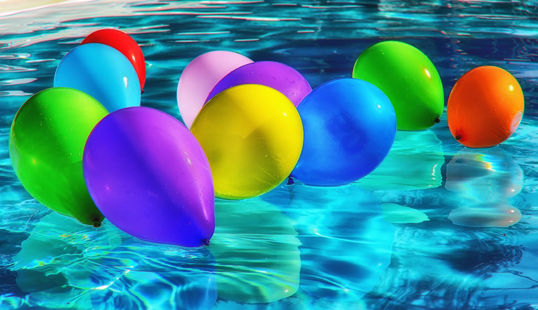 purple yellow and blue balloon on swimming pool