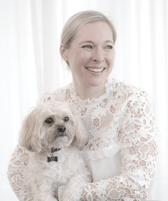 Cara Zelas author and educator holding her dog