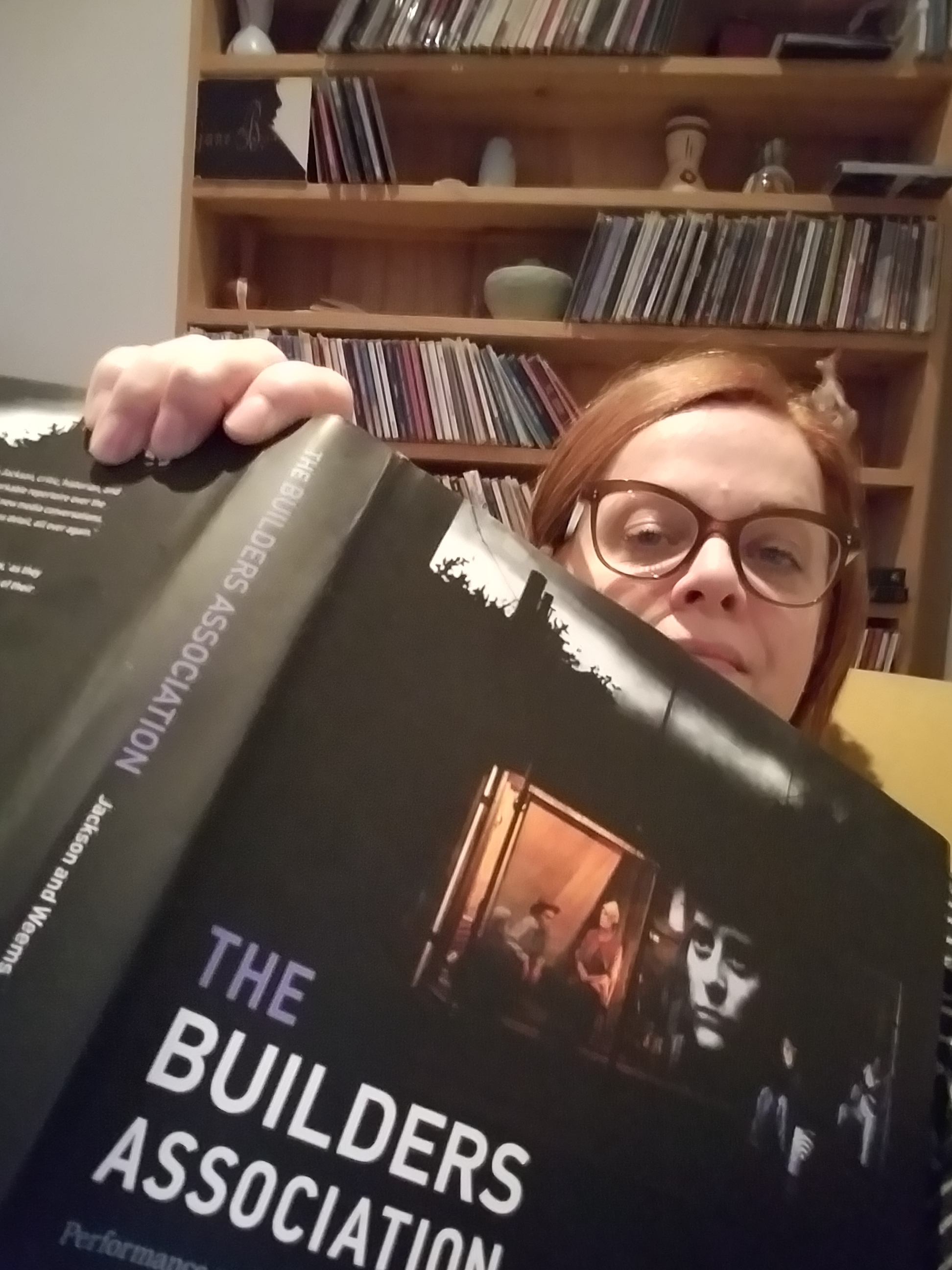 Australian woman with glasses reading a book at home