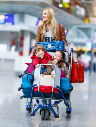 mother pushing a cart with children, kids and suitcases at the airport