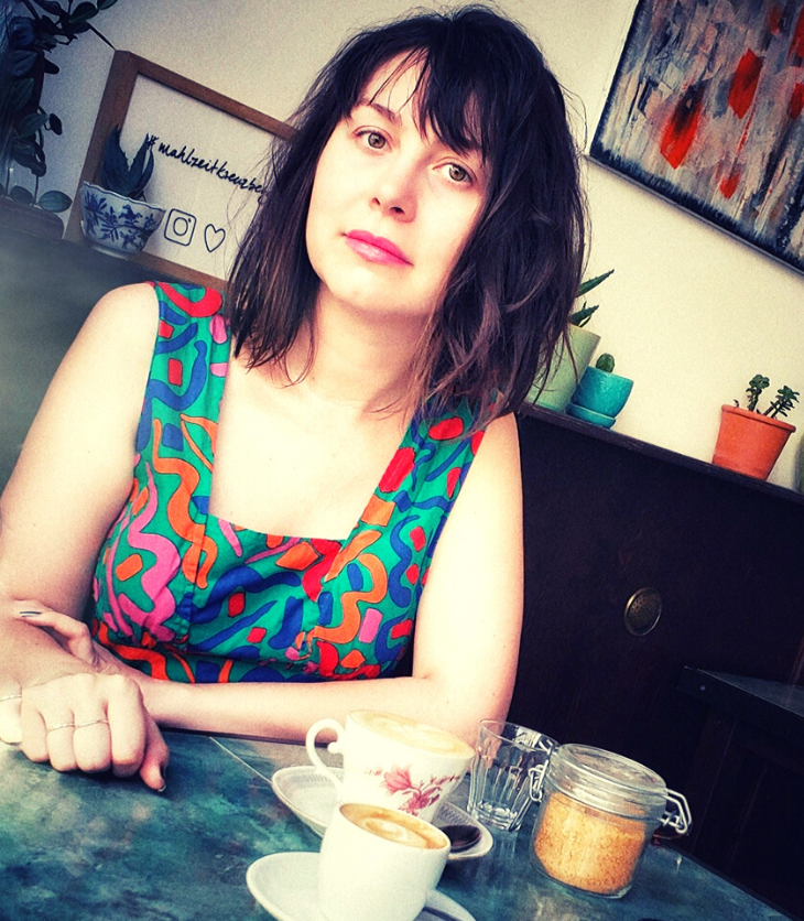 Australian woman in Brooklyn coffee shop cafe with cup of coffee
