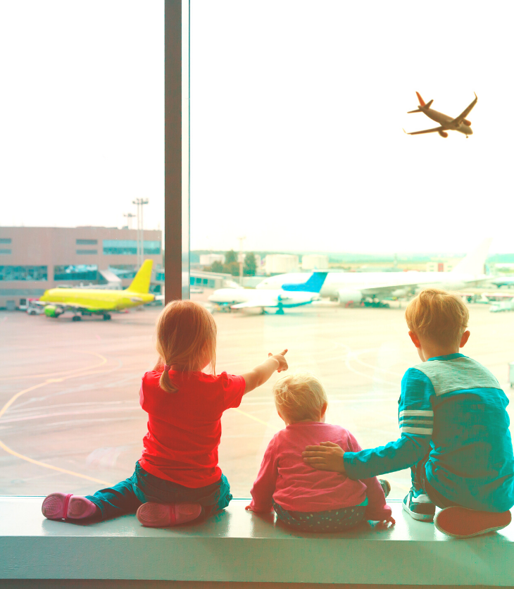 kids at airport looking at airplane