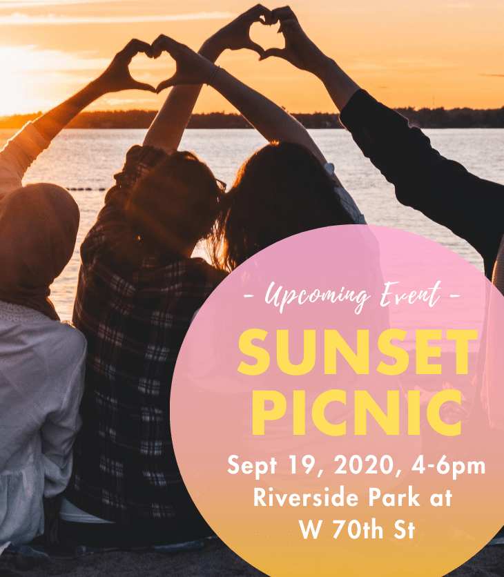 people standing by river holding hands up to sunset